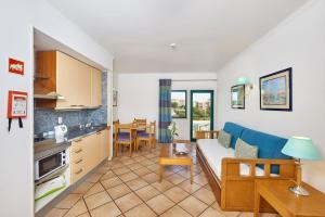 a living room with a couch and a kitchen at Oceanus Aparthotel in Albufeira