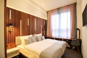 a bedroom with a white bed and a window at H24 Berlin Lichtenberg in Berlin