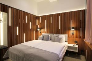 a bedroom with a white bed and a wooden wall at H24 Berlin Lichtenberg in Berlin
