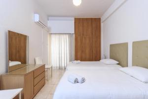 Habitación de hotel con 2 camas y espejo en Les Palmiers House, en Lárnaca