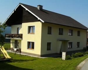 a large house with a slide in front of it at Bauernhof Manuela Perner in Nussdorf am Attersee