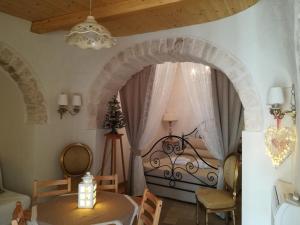 una camera con letto, tavolo e sedie di Resort Romano in Trulli ad Alberobello