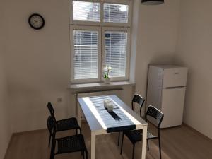La cuisine est équipée d'une table, de chaises et d'un réfrigérateur. dans l'établissement apartma Delavska, à Maribor