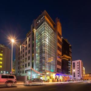 wysoki budynek z mnóstwem okien w nocy w obiekcie MENA ApartHotel Albarsha At The Mall w Dubaju