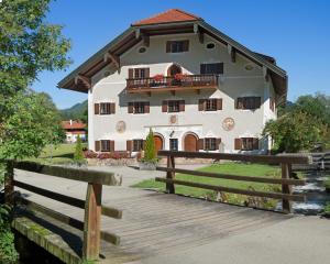 ein großes Haus mit einem Holzzaun davor in der Unterkunft Huberhof in Ruhpolding