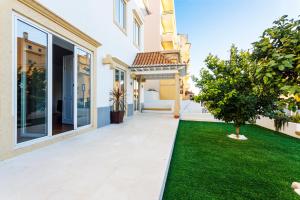 une maison avec une cour avec de l'herbe verte dans l'établissement Chalet Estoril Luxury Apartments, à Estoril