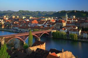 a city with a bridge over a river with buildings at apartma Delavska in Maribor +3 photos