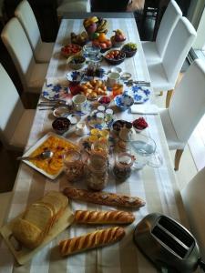 ein langer Tisch mit Frühstückszutaten drauf in der Unterkunft B&B Loft Trotters in LʼÉtang-la-Ville