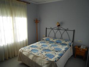 Hostal Donaire II في توميلوسو: غرفة نوم بسرير ونافذة