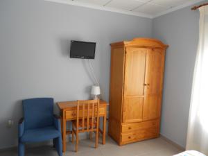 1 dormitorio con mesa, silla y armario en Hostal Donaire II, en Tomelloso