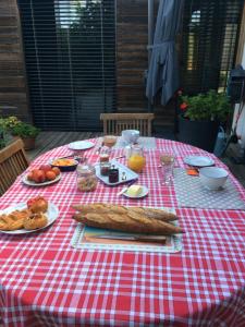 a picnic table with food on a red and white checked table cloth at Les Terrasses de Rochetaillée in Rochetaillée