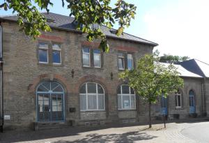 Im Bahnhof - Gästezimmer - في فايكرزهايم: مبنى من الطوب وامامه شجرة