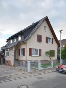 una casa blanca con techo de gambrel en una calle en Apartment Moritz, en Lahr