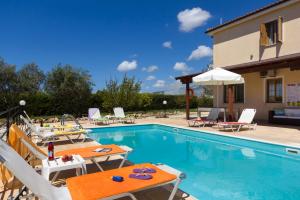 - une piscine avec des chaises et des tables à côté d'une maison dans l'établissement Panareti Coral Bay Resort, à Coral Bay
