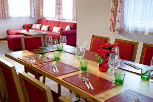 una mesa de madera con copas de vino y un jarrón con flores en AlpenChalet Mitterberg, en Mariapfarr