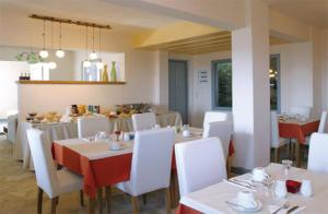 a dining room with white tables and white chairs at Serie in Ioulis