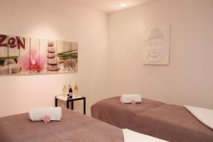 a room with two beds and a statue on the wall at Le César Hôtel in Provins