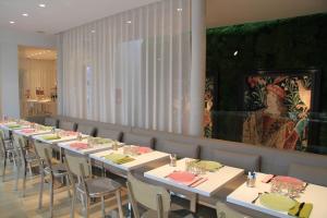 a dining room with long tables and chairs at Le César Hôtel in Provins