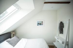a white bedroom with a bed and a window at LOFT-ATELIER in Hamburg