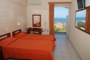 a bedroom with a bed and a view of the ocean at Captains Hotel in Argassi