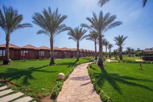 a resort with palm trees and a walkway at Xperience Golden Sandy Beach in Sharm El Sheikh