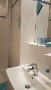 a white bathroom with a sink and a mirror at Hotel Schlosschänke in Hannoversch Münden +10 photos