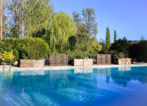 a swimming pool with chairs and blue water at Les Trois Soleils in Saint-Céré