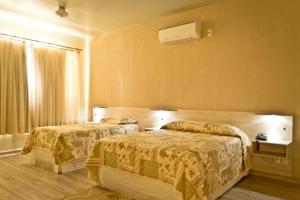 ein Hotelzimmer mit 2 Betten und einem Fenster in der Unterkunft Pampa Hotel in Vacaria