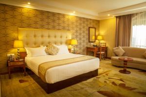 a hotel room with a bed and a couch at Jupiter International Hotel - Bole in Addis Ababa