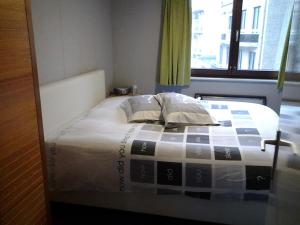 een slaapkamer met een bed met een geruite deken bij Zonnig Appartement met Zeezicht in Koksijde