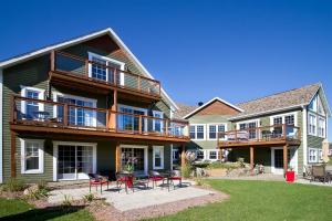 a large house with chairs and tables in the yard at Gî'Temps couette et café B&B in Granby