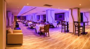 un restaurante con mesas y sillas en una habitación en Marco Polo Hotel en Manama