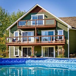 a house with a swimming pool in front of it at Gî'Temps couette et café B&B in Granby