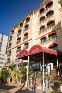 un edificio de hotel con sombrillas rojas delante en Jupiter International Hotel - Bole, en Addis Ababa