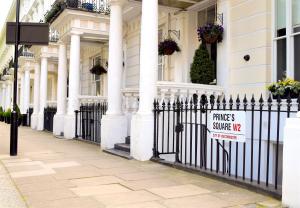 un cartello su una recinzione di fronte a una casa di Pembridge Palace Hotel a Londra