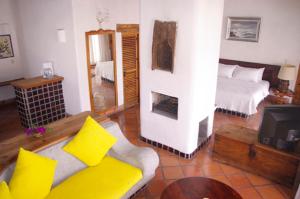 a living room with a bed and a tv at Posada de la Mision, Hotel Museo y Jardin in Taxco de Alarcón