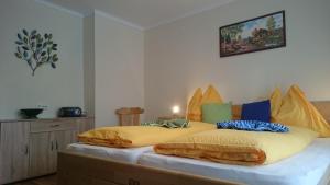 シュラートミンクにあるHaus Hubertusheimのベッドルーム1室(大型ベッド1台、黄色いシーツ付)