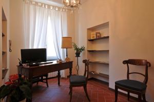 um quarto com uma secretária, um computador e 2 cadeiras em B&B Il Grifone em Pistoia