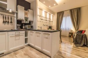 uma cozinha com armários brancos e uma bancada em Ugo Bassi Apartments em Bolonha