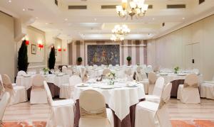 a ballroom with white tables and chairs and a chandelier at Felipe IV in Valladolid
