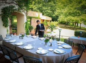 un homme en costume debout devant une table dans l'établissement Les Trois Soleils, à Saint-Céré