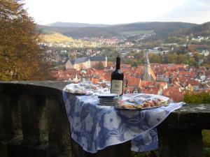a table with a bottle of wine and a plate of food at Hotel Schlosschänke in Hannoversch Münden