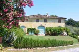 une maison ancienne avec un jardin et des fleurs dans l'établissement Azienda Agricola Fabbrica Di San Martino, à Lucques