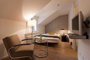 Cette chambre comprend un lit, une table et une télévision. dans l'établissement Baseltor Hotel & Restaurant, à Soleure