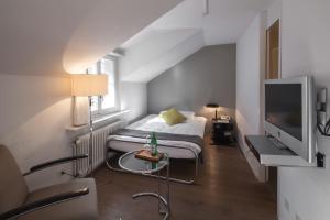 a small room with a bed and a tv at Baseltor Hotel & Restaurant in Solothurn