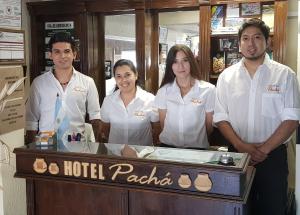un grupo de personas de pie frente a un mostrador de recepción del hotel en Hotel Pachá en Salta