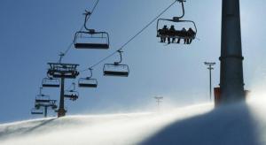 a group of people riding a ski lift in the snow at Le Cristal 2 in Les Gets