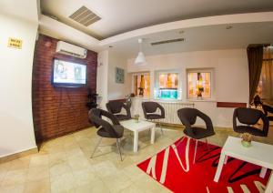 a waiting room with chairs and a red rug at Atrium Hotel Bucharest City Center in Bucharest