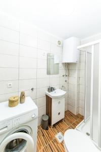 een badkamer met een wasmachine en een wastafel bij Apartman Centar in Banja Luka