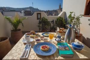 - une table avec petit-déjeuner sur le balcon dans l'établissement Dar Essoaoude - Fes Nejjarine, à Fès